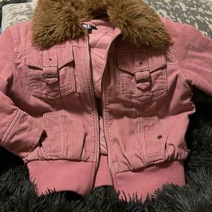Dark pink. Corduroy jacket with fur around the neck buttons at the Wrist.